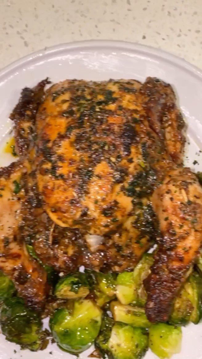Roasted cornish hen with herbs served with a side of Brussels sprouts