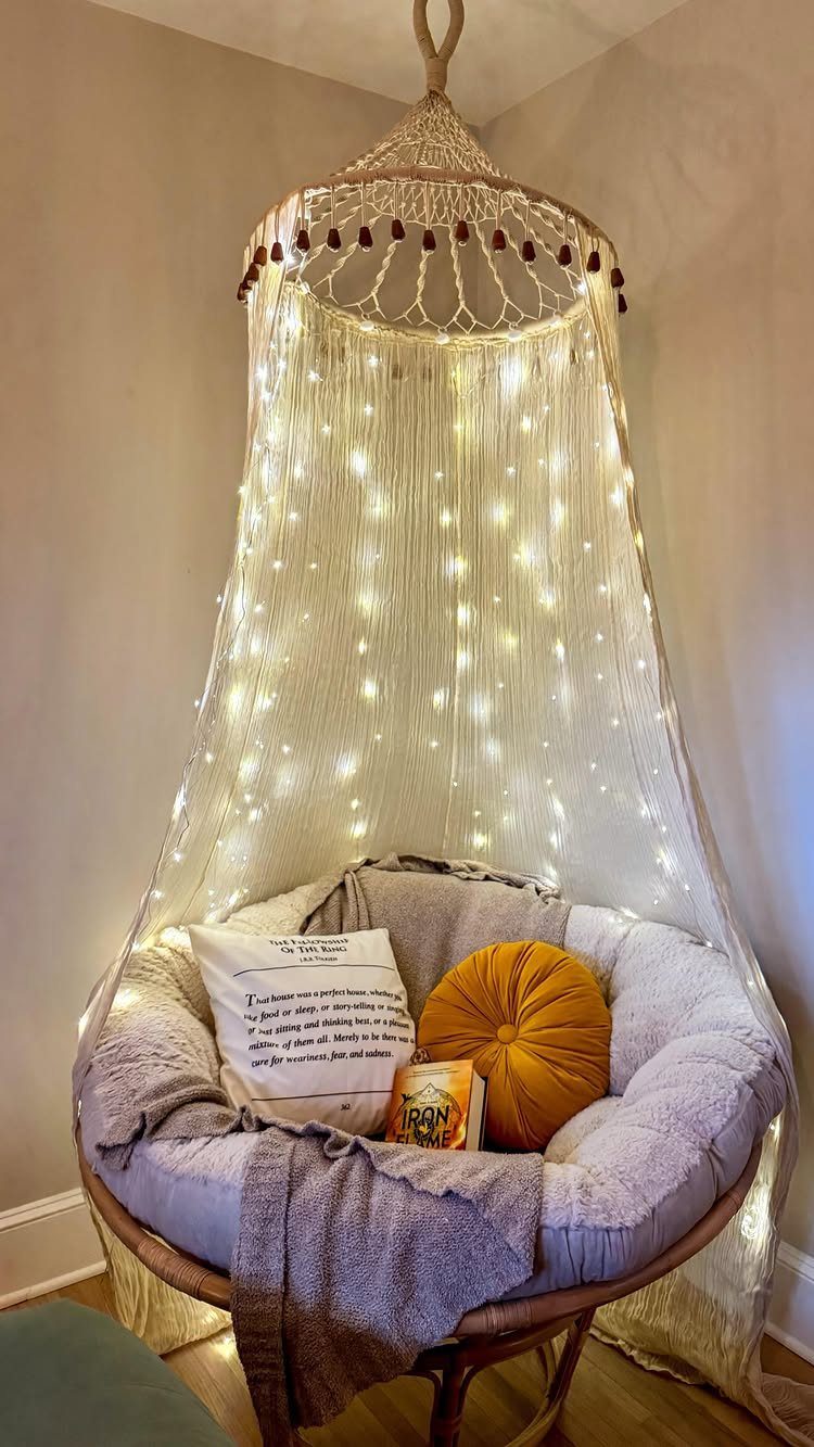 Hanging papasan chair with yellow pillow and fairy lights under a macrame canopy.