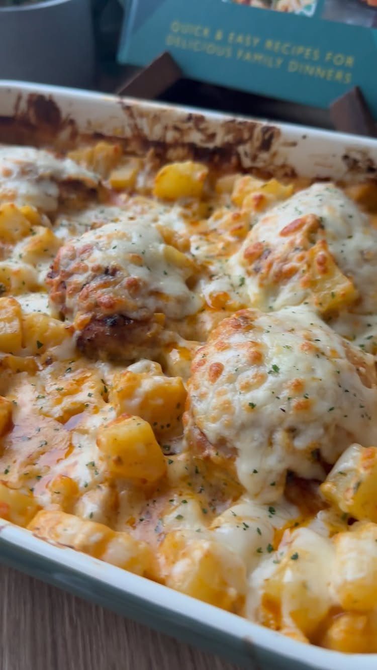 Cheesy potato and meat casserole in a white baking dish with melted cheese.